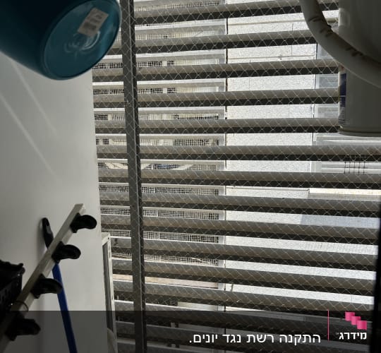 רשת מתכת על חלון למניעת כניסת יונים
